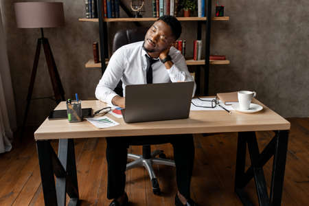 Handsome african business man tired after work in modern office