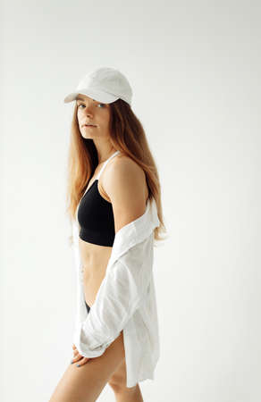 Athletic beautiful woman in white studio, wearing sport underwear, having a good shape, recommends...