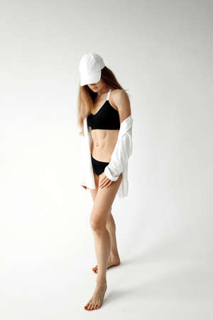 Sporty lady posing over white background in studio, lovely woman having beautiful shape, recommended healthy lifestyle, daily workout, beauty conceptの写真素材
