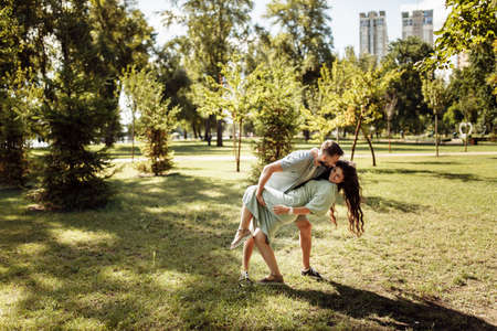 Overjoyed couple dancing at the park, loving husband hold in arms beautiful wife, pretty woman smiling, enjoy happy time together, relaxing, healthy relationship concept. High quality photoの写真素材