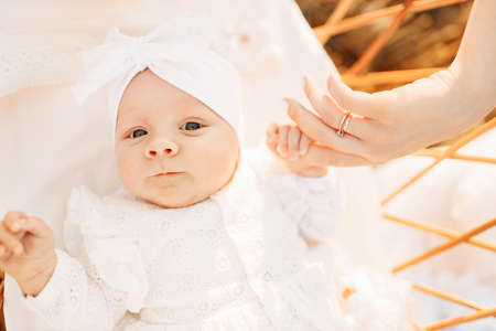 Wonderful newborn baby girl laying in the bed, little child look around with big interest, cute daughter hold mother finger, childhood and motherhood concept. High quality photoの写真素材