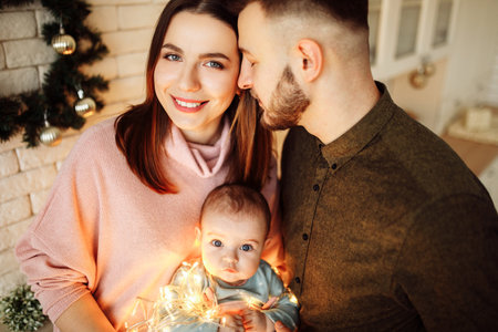 Beautiful young family with little daughter at the kitchen, decorate the house for Christmas...