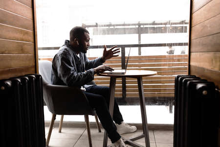 Pensive African American businessman looking at laptop screen, leads video confirmation. With...