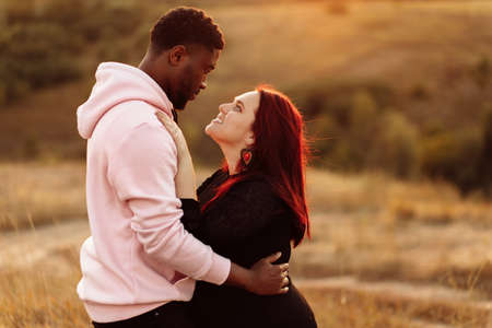 Portrait of attractive African American man gently hug beautiful white woman, adorable lady smiling, enjoy tender moments, spend time together, mixed race couple concept. High quality photoの写真素材