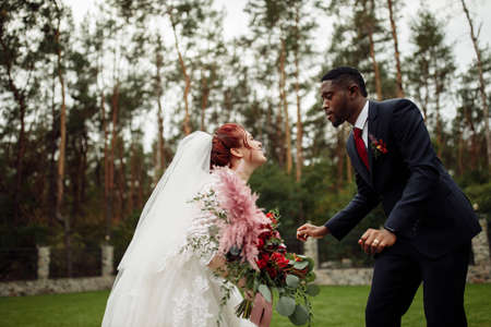 Overjoyed couple dancing, handsome African American man with lovely white woman on wedding day, beautiful bride with charming groom enjoy happy moment, marriage concept. High quality photoの写真素材