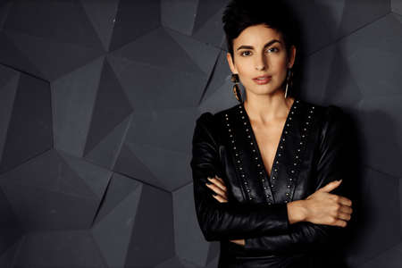 Portrait of serious elegant female leader look at the camera, wearing stylish dress. Beautiful elegant business woman posing with cross hands, attractive gorgeous lady boss show confidence and successの写真素材