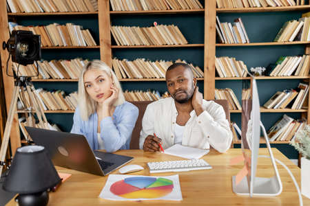Portrait of stylish multiracial business partners at the workplace, looking at the camera. Successful confident colleagues working together on project in office, using laptop, teamwork conceptの写真素材