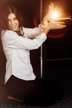 Indoor shot of a sitting charming charismatic and delighted working woman in stylish outfit playing...