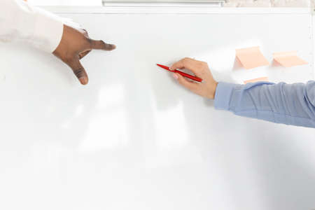 Happy business partners working together on project in office, smiling, using laptop. Multiracial successful colleagues discussing new startup, searching ideas, teamwork concept. High quality photoの写真素材