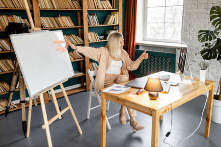 Happy young beautiful female student showing thumb up, enjoying studying remotely.Cheerful...