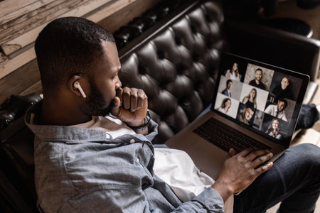 Exhausted tired African American businessman sitting at work desk with closed eyes, falling asleep,...