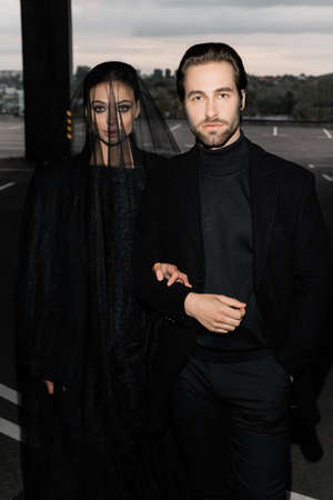 Portrait of fashion marriage couple on the photoshoot, looking at the camera in stylish wedding...