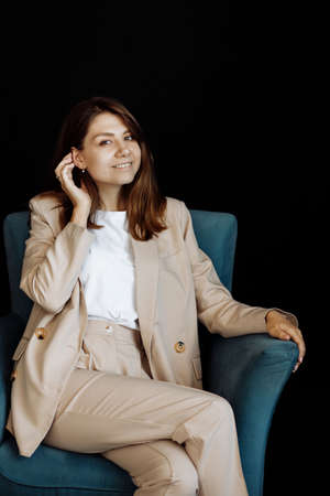 Young beautiful girl posing for a photo. Cute smiling looking at the camera while sitting in a chair...