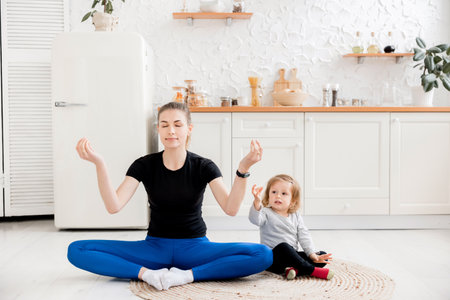 Beautiful calm athletic girl and daughter doing namaste, yoga,meditation or fitness instructor, attractive female trainer in sportswear , meditation to deal with stress. wellbeing and serenity concept.の写真素材