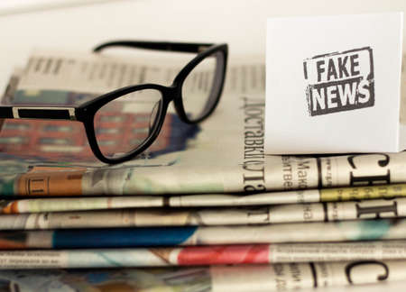 Fake news, disinformation or false information and propaganda concept. . Broken glasses with the inscription.の写真素材