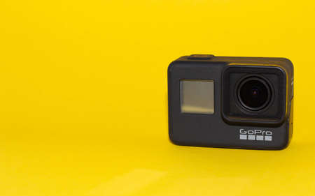 Go pro camera on a yellow background. Isolated object