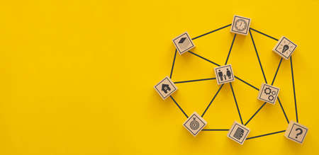 Social media and internet concept. Network of people icons on wooden cubes on yellow background.