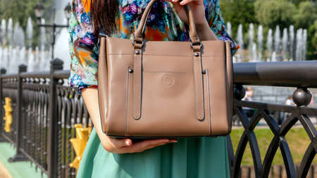 woman lather bag hand holding bag Beautiful fashion outfit, red skirt and black big leather bag in hand of girl . Stylish accessoryの写真素材