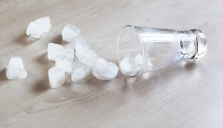 Turned over glass and ice cubesの写真素材