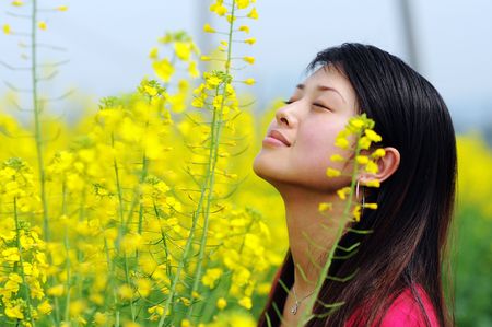 A pretty chinese women in rape flowers.