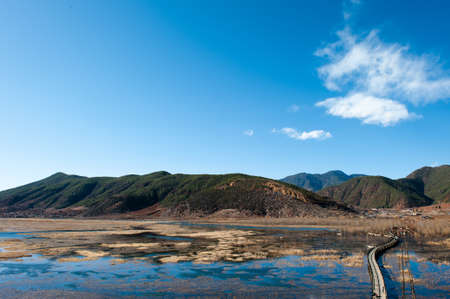 woods bridge in lake and blue sky at lugu lake.の写真素材