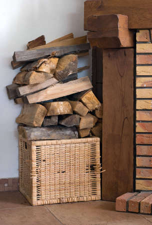 Firewood in a basket near a fireplaceの写真素材