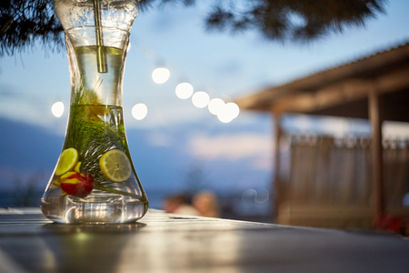 Modern Hookah for tobacco smoking made of metal, glass and plastic on wooden table.The background-summer sunny garden. Selective focus.の写真素材