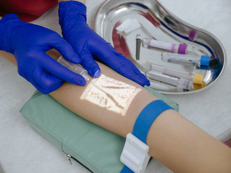 Cropped image of nurse taking blood for analysis via veins projector deviceの写真素材