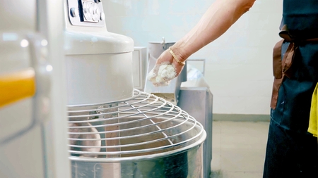 industrial dough mixing machine kneading dough for bread, close-up