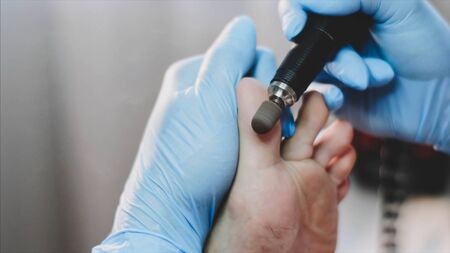 Hands of pedicurist remove old skin on clients big toe makes hardware pedicure.の写真素材