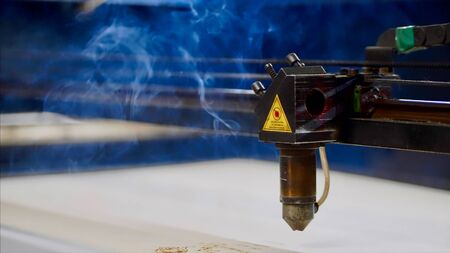 Industrial laser cutter is working with smoke.