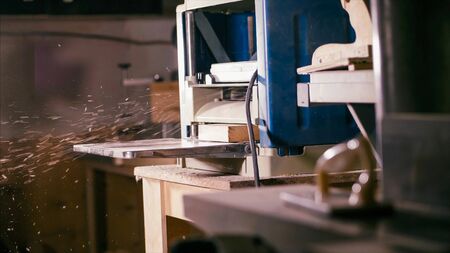Cabinet planer machine is working with sawdust at wood workshop . Process of work surf gage machineの写真素材