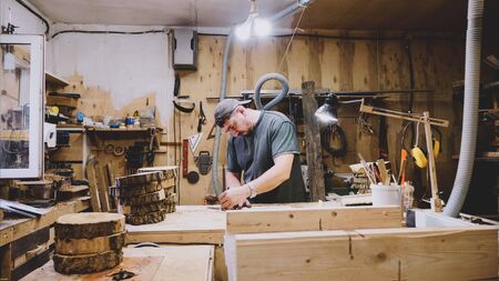Male carpenter is working at carpentry, wide angle