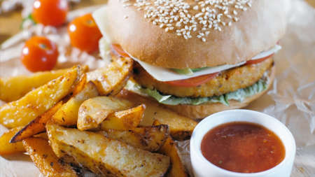 Crispy rustic potatoes with hamburger on wooden board. Fast food concept.の写真素材