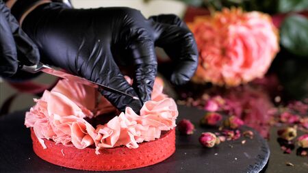Confectioner is making a dessert with petals from pink chocolate