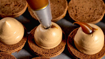 Chef is making caramel macarons, close-up.