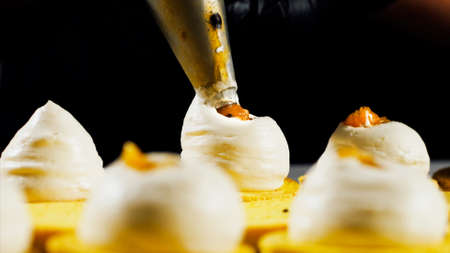 Chef is making batch of colorful macarons, close-up.の写真素材