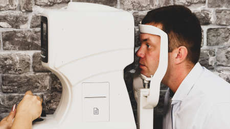 Portrait of man during test on refractometer machine.の写真素材
