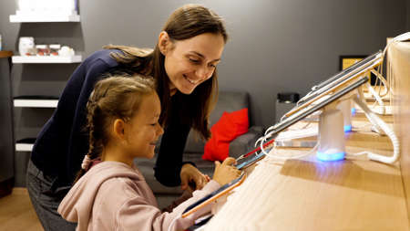 Mother with daughter choosing a new smartphone in an electronics store.の写真素材