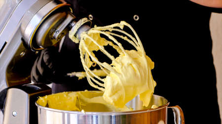 The cook is making yellow creme in professional blender for making dessertの写真素材