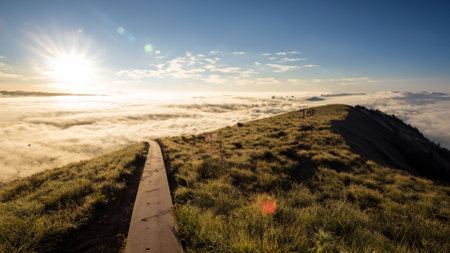 Sunrise on top of the mountain with a path through the cloudsの素材