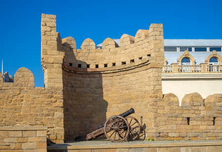 An ancient cannon against the background of the wall of the Old City. Historical center of Baku, Azerbaijanの写真素材