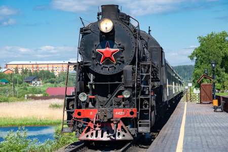 KARELIA, RUSSIA - JUNE 11, 2022: An old steam locomotive L-4429 with a retro tourist train...