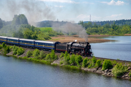 RUSKEALA, RUSSIA - JUNE 11, 2022: Steam locomotive with a old tourist train "Ruskeala Express" on the dam of Lake. Kareliaのeditorial素材