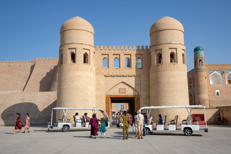 KHIVA, UZBEKISTAN - SEPTEMBER 07, 2022: Tour cars with tourists at the walls of the old town of Ichan-Kala. Khiva, Uzbekistanのeditorial素材