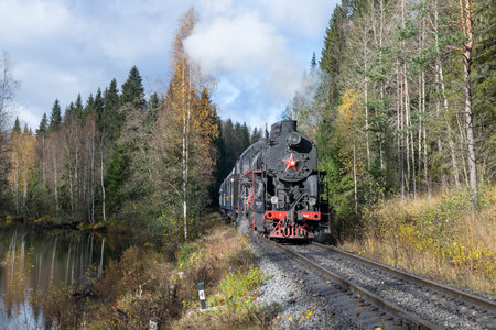 RUSKEALA, RUSSIA - OCTOBER 09, 2022: An old steam locomotive on a forest stretch in Karelia. Russia