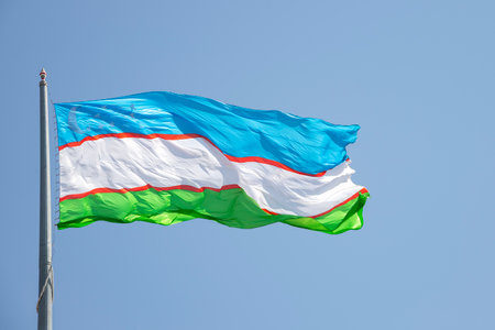 The national flag of Uzbekistan on a blue sky backgroundの写真素材