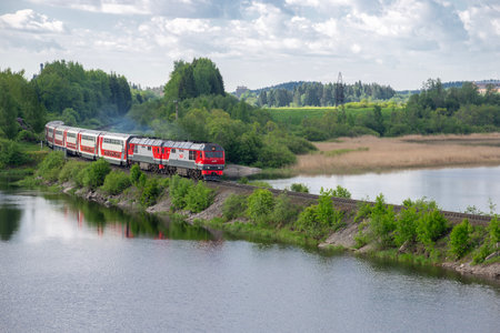 KARELIA, RUSSIA - JUNE 11, 2022: Double-decker passenger train on the lake dam. Karelia, Russiaのeditorial素材