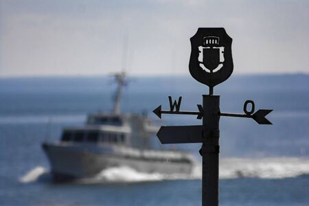 West-east sign in the background of a floating boat