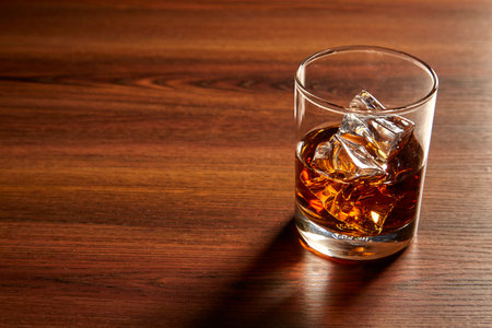 A Glass of whiskey on ice on wood tableの写真素材